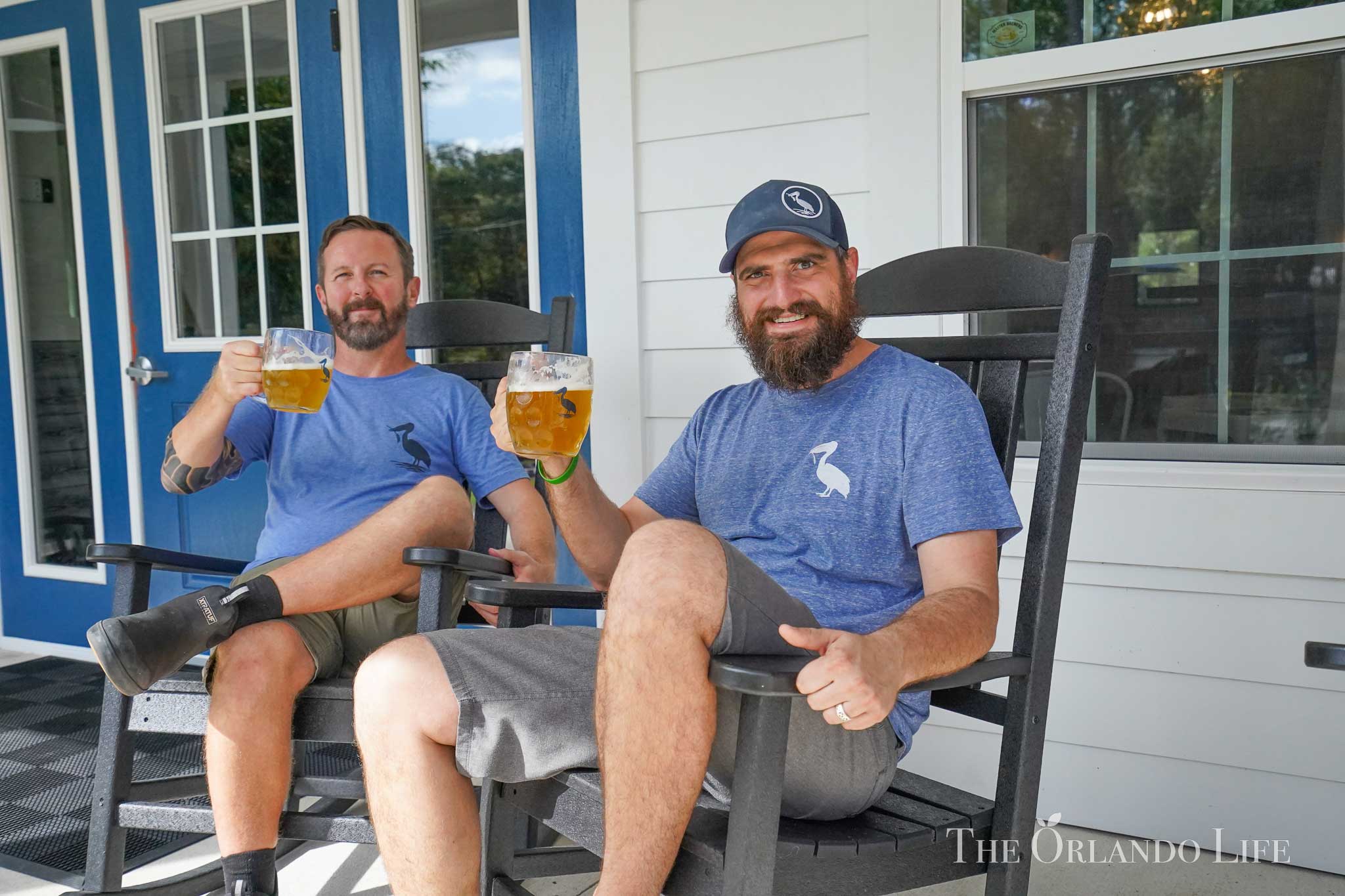 Andy McGee and Aaron Anderson from Windermere Brewing Co sit on the brewery's front porch enjoying a beer